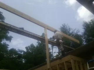Carpenter setting a ridge beam over a new addition frame — Ice Dam Removal by Roofing Brothers in Bear Lake