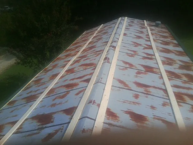 Rusted metal roof panels with new wood purlins before replacement — Storm Damage Roof Repair in Bear Lake by Roofing Brothers