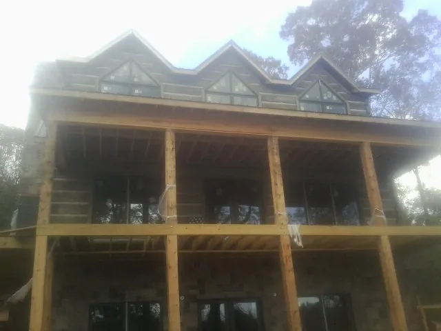 Dormers and porch framing on a large log home under construction — Roof Coating work by our crew in Bear Lake