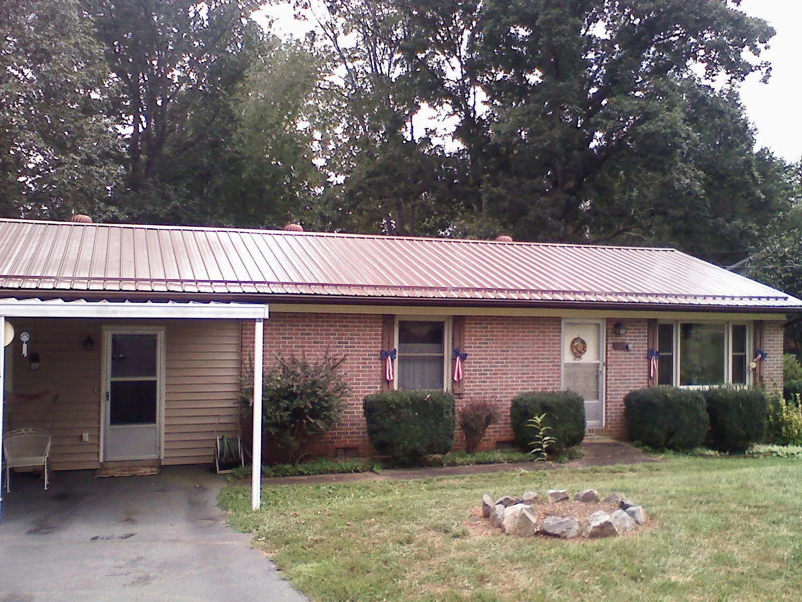 Bronze metal roof and carport on a brick ranch home — Roof Repair work by our crew in Bear Lake